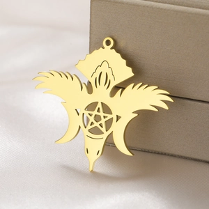 Macro shot of gold-plated celestial pendant with star and wings on soft silk