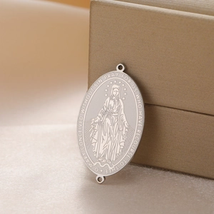 Detail of Virgin Mary oval pendant with dual rings on gold silk background