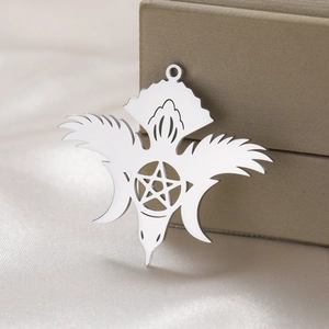 Macro shot of silver stainless steel moon and star hollow pendant on white silk fabric