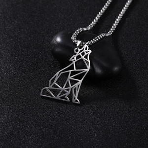 Detail van geometrische wolf-hanger aan zilveren ketting op een zwarte kiezelsteen