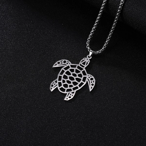 Detail van een opengewerkte zilveren zeeschildpad hanger aan een ronde bakketting