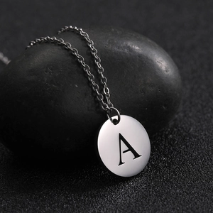 Polished stainless steel letter A pendant necklace on black stone background