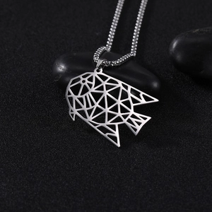 Macro-detail van geometrische zilveren vis-hanger op zwarte stenen met ketting