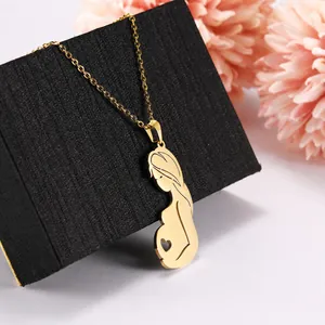 Gouden ketting met hanger van zwangere vrouw silhouet en hart op zwarte geschenkdoos