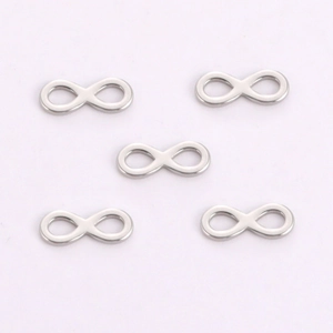 Macro detail of five silver infinity symbol pendants in polished stainless steel finish