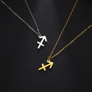 Vue détaillée des pendentifs Sagittaire en argent et or sur fond noir mat élégant