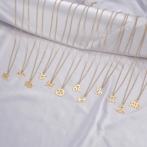 Parure de colliers en acier doré avec 12 pendentifs des signes du zodiaque sur satin