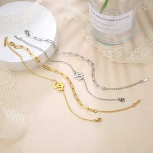 Macro view of Om symbol pendants on gold and silver paperclip and fine link chains