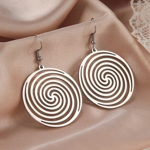 Detailed view of silver stainless steel spiral swirl dangle earrings on silk fabric