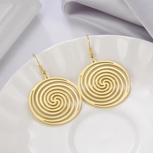 Minimalist gold spiral hoop earrings with etched swirl pattern on a ceramic dish