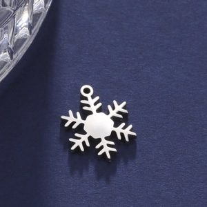 Makroaufnahme von silbernem Schneeflocken-Anhänger aus poliertem Edelstahl für DIY-Schmuck