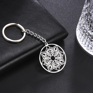 Detailed view of silver hollow geometric floral pattern keychain on black leather background