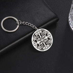 Polished silver stainless steel keychain with hollow floral pattern on a black surface