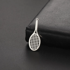 Macro shot of mirror-polished stainless steel tennis racket pendant on black leather surface