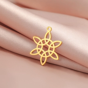 Vue détaillée d'un pendentif nœud celtique doré sur un élégant tissu en soie rose