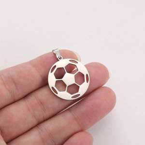 Detail of hollowed-out stainless steel soccer pendant with a polished silver finish