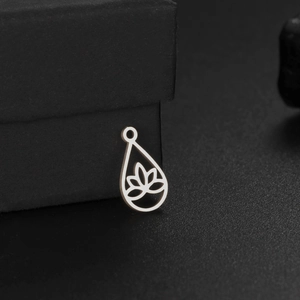 Pendentif goutte d'eau lotus évidé en argent sur boîte à bijoux noire, vue de côté