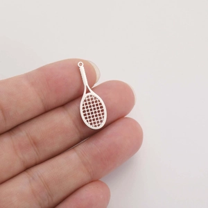 Macro view showing a tiny stainless steel tennis racket charm held between fingers