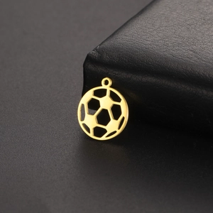 Gros plan d'un pendentif ballon de foot évidé en or 18K sur fond de cuir noir texturé