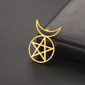 Macro detail of 18K gold plated star and moon pendant with matte brushed metal texture