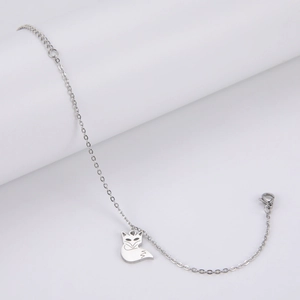 Detalle de pulsera con dije de zorro plateado y acabado en metal pulido brillante