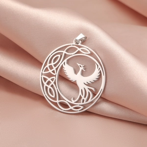 Detailed macro view of a silver phoenix Celtic knot pendant on pink silk fabric
