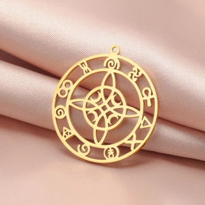 Golden Celtic knot pendant with mystical symbols on a soft pink satin fabric