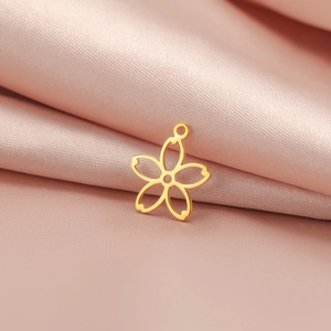 Gros plan détaillé d'un pendentif lotus en métal doré sur du tissu en satin rose