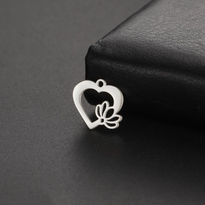 Vue détaillée du pendentif cœur ajouré et lotus avec une finition argent poli