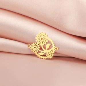 Detail van de gouden roestvrijstalen madeliefje hanger op zachte roze zijde stof