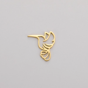 Macro view of gold-plated stainless steel hummingbird pendant with hollow-out lines