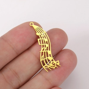 Détail macro d'un pendentif en acier inoxydable plaqué or 18K motif musique