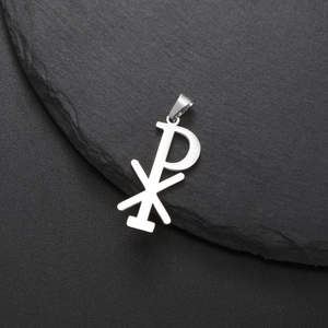 Silver stainless steel Chi-Rho religious pendant on a dark stone background
