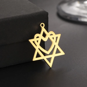 Polierter goldener Hexagramm-Herz-Anhänger an einer dunklen Schmuckschatulle
