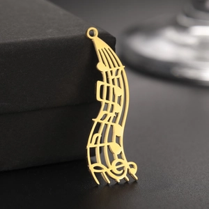 Vue macro du pendentif note de musique en acier inoxydable doré 18K aux lignes épurées