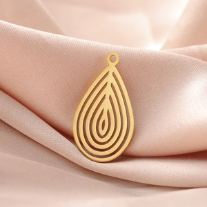 Polished 18K gold plated stainless steel teardrop pendant on soft pink silk background