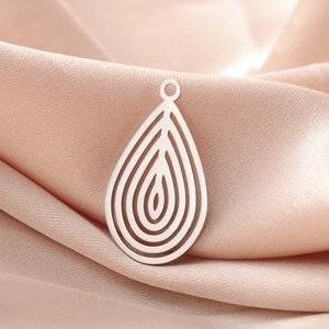 Detailed view of silver water drop hollow pendant on a pink silk background