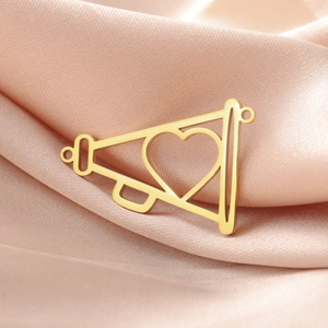 Macro di un ciondolo a cuore in acciaio inossidabile dorato su elegante raso rosa