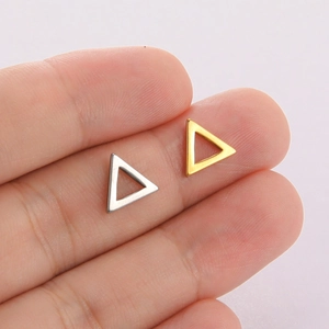 Minimalist hollow triangle stud earrings in polished gold and silver held on fingertips