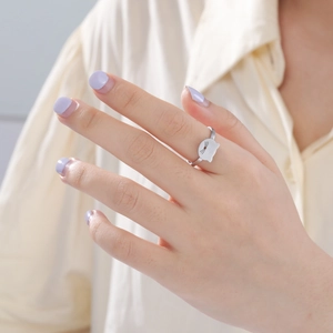 Close-up of a silver hollow cat ring on a finger with adjustable open band design