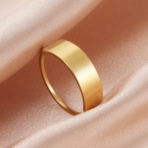 Anello in acciaio inossidabile dorato lucido su elegante sfondo di seta drappeggiata