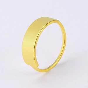 Dettaglio macro di un anello a sigillo dorato minimalista con superficie piatta lucida