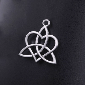 Colgante de corazón con nudo celta Triquetra plateado pulido sobre fondo negro