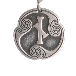 Detalle macro del colgante de plata antigua con alfabeto rúnico y espiral celta