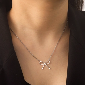 Elegante zilveren roestvrijstalen ketting met strikhanger gedragen op een model