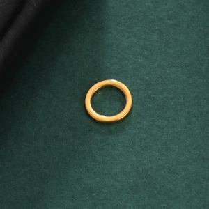 Makroansicht des polierten 18K vergoldeten Edelstahlrings auf dunklem Hintergrund