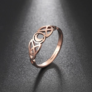 Detail van een roségouden open ring met keltische knoop en maan op zwarte achtergrond