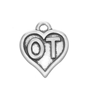 Gros plan d'un pendentif cœur vintage en argent vieilli avec lettres OT en relief