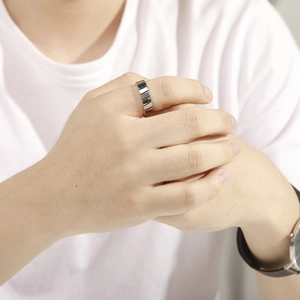 Gros plan d'une bague géométrique minimaliste en acier inoxydable à motifs blocs