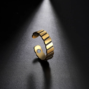 Détail d'une bague réglable en titane doré avec rayures verticales et deux aimants de thérapie